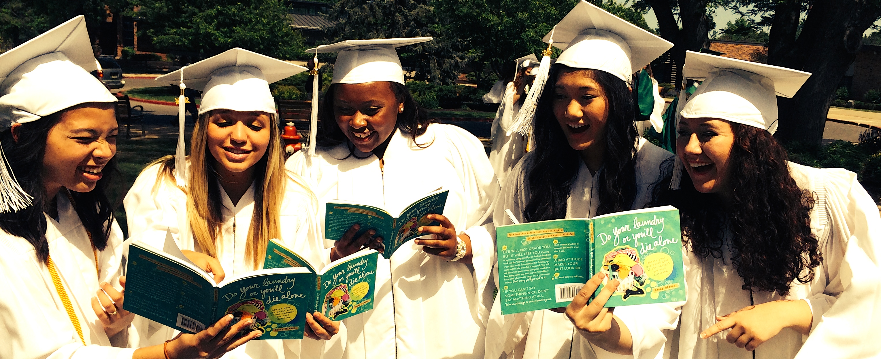 friends at graduation ceremony reading do your laundry or you'll die alone book